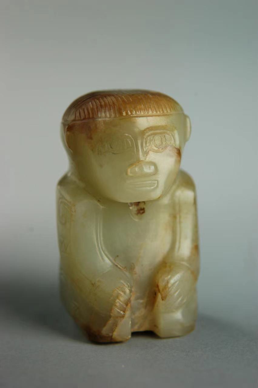 Xunzai human-shaped jade pendant Late Shang Dynasty (13th century BC - 1046 BC) Height 5.6 cm, width 2.8 cm Unearthed from Fuhao Tomb, Xiaotun, Anyang in 1976, Henan Museum Collection Made of sapphire, jade quality is bright and smooth, round carving. The figure is sitting in a sundae shape, with both hands on the knees, and the arms are slightly bent inward. The forehead is broad, the words of minister, the nose of garlic, the mouth slightly open, and the short hair on the top of the head for a week. Dressed with long sleeves and narrow neckline, with a high back neck. There is a small hole between the neck and the back of the head, and there is also a hole between the legs for wearing or inserting. Sundae sitting, that is, the knees and calves are on the ground, the heels support the buttocks, and the upper body is upright. It was a very important sitting posture in the Shang Dynasty. Among the figures of the Shang and Zhou dynasties unearthed so far, most of the round-carved utensils adopt this posture.
